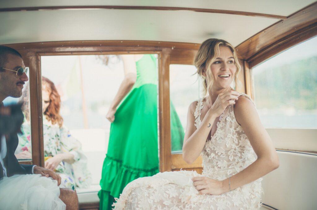 bride going to the church in a boat for a destination wedding in laghi italy