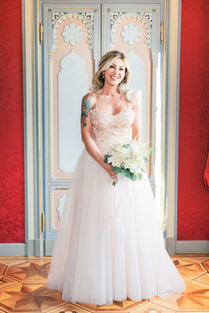 beautiful bride pausing in front of a red wall for a destination wedding in italy planned by atelier crespi
