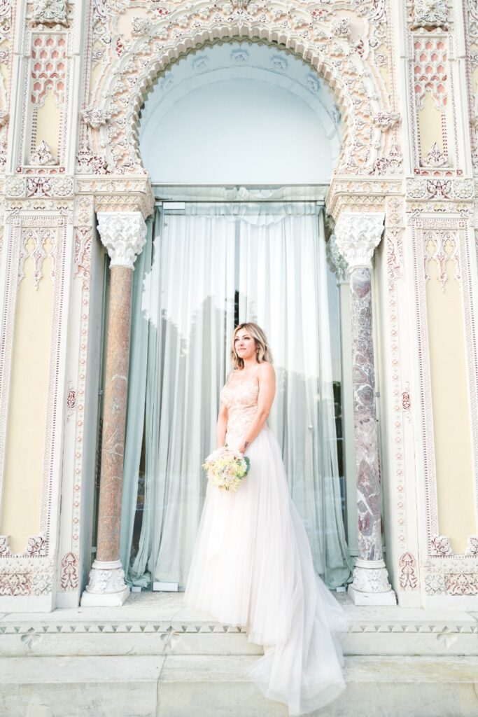 bride in front of the amazing wedding venue in italy posing for a photograph